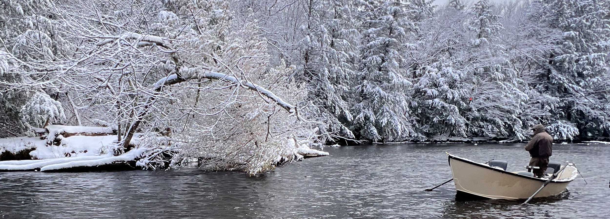 photo of Salmon River in the winter showing a driftboat in the river and someone fishing from the driftboat